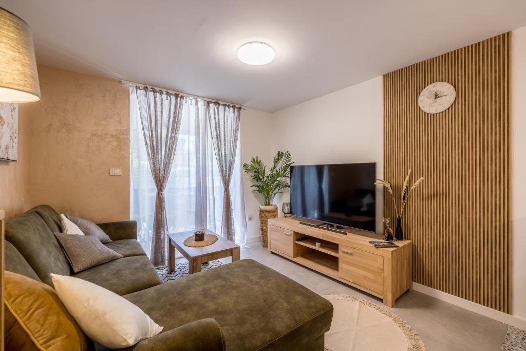 Televízia a/alebo spoločenská miestnosť v ubytovaní Olive Shade - Apartment near the Beach
