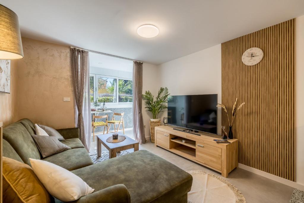 Televízia a/alebo spoločenská miestnosť v ubytovaní Olive Shade - Apartment near the Beach