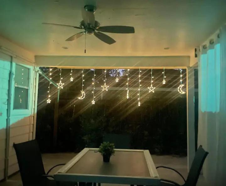 a dining room table with a ceiling fan and lights at Peaceful Forest Shadow in Humble