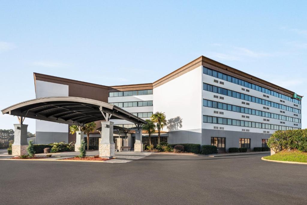 ein großes Bürogebäude mit Parkplatz in der Unterkunft Holiday Inn Mobile West I-10, an IHG Hotel in Tillmans Corner