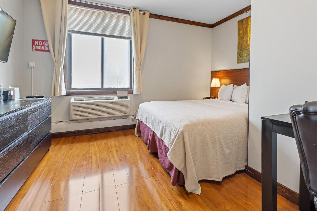 ein Hotelzimmer mit einem Bett und einem Fenster in der Unterkunft LIC Hotel in Queens