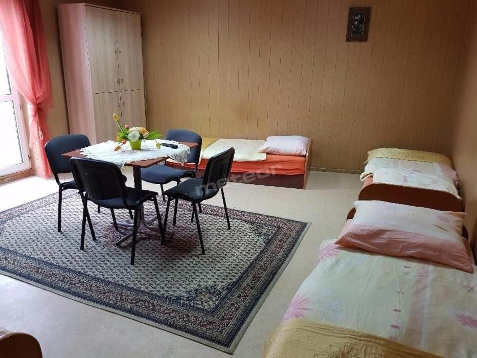 Habitación con mesa, sillas y 2 camas en ALFA Noclegi en Jędrzejów