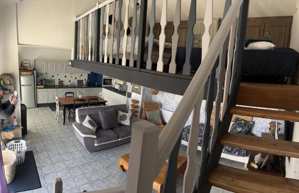 un salon avec un escalier et une cuisine dans l'établissement Appartement mezzanine spacieux, à Jaunay-Clan