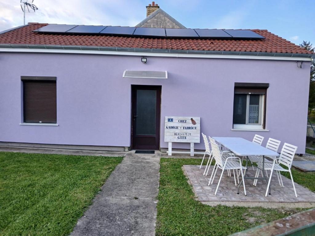 a white house with a table and chairs at La petite maison Lavandin 