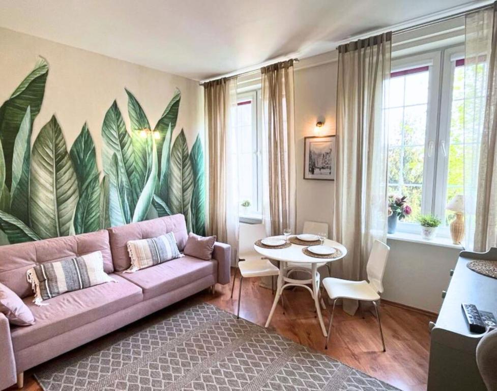 a living room with a pink couch and a table at Apartament Kameralny 12 in Gdańsk