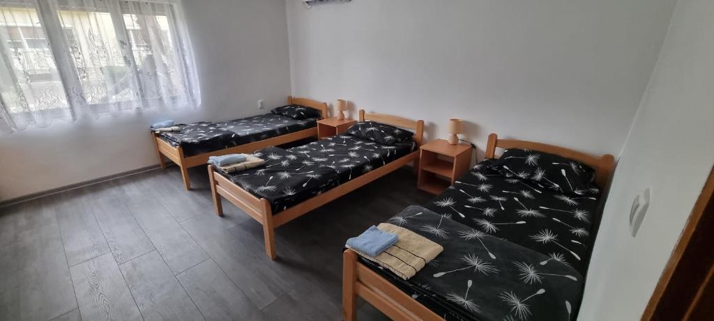 een kamer met drie bedden in een kamer bij MILOJEVIĆ APARTMANI in Bečej