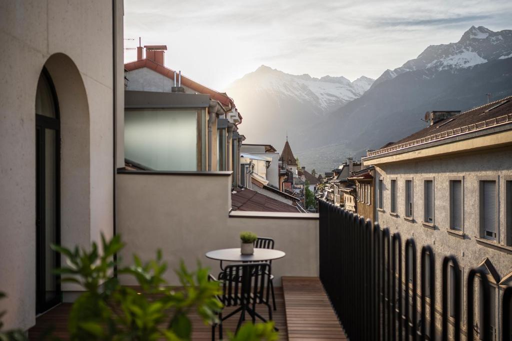 a balcony with a table and a view of mountains at Mynt Merano Rooms in Merano