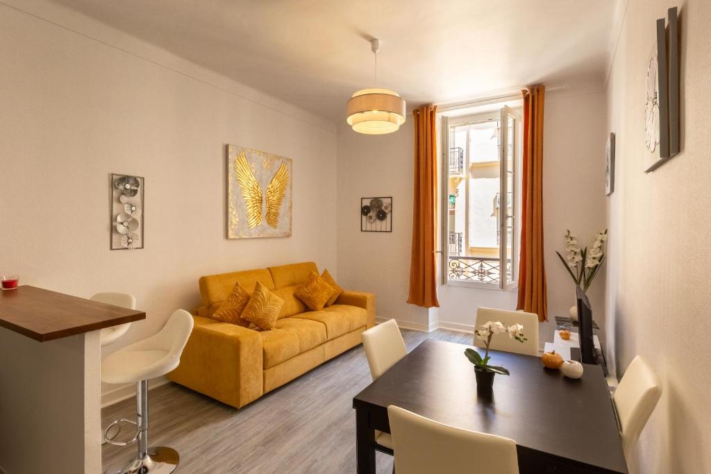ein Wohnzimmer mit einem gelben Sofa und einem Tisch in der Unterkunft Elegant 2 rooms in the heart of Cannes in Cannes