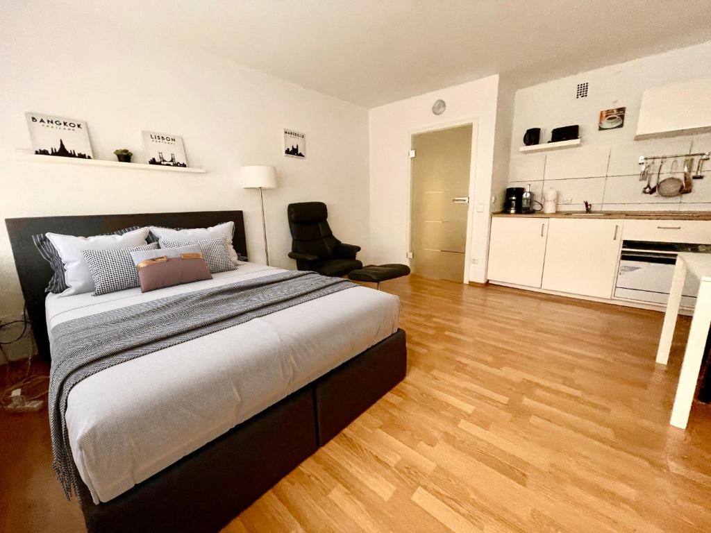 a bedroom with a large bed and a kitchen at Premium Studio Flingern in Düsseldorf