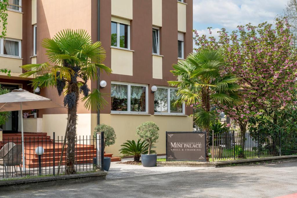 un bâtiment avec des palmiers en face de celui-ci dans l'établissement Hotel Mini Palace - Country House, à Molinella