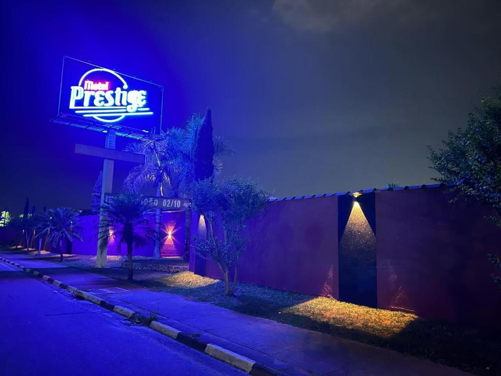 Motel Prestige Pinda في بيداموهانغابا: مطعم مع لافتة نيون على جانب المبنى