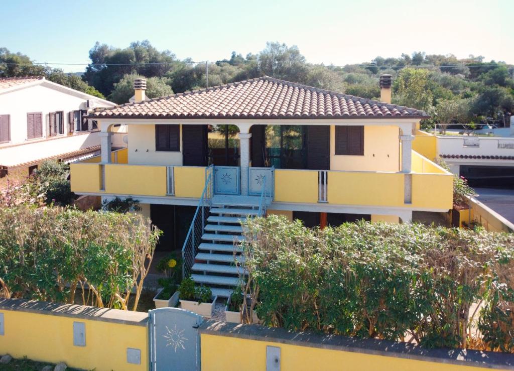 una casa gialla con portico blu e scale di CASA ARCO DE CHELU a Santa Lucia