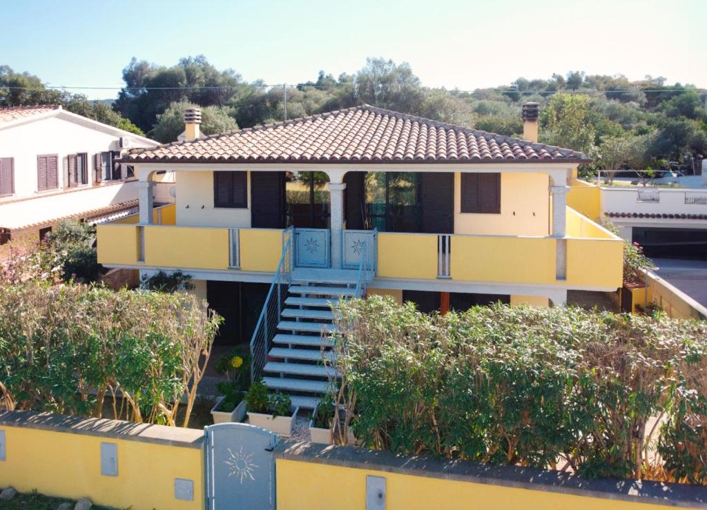 a yellow house with a blue porch and stairs at Casa ARCU DE CHELU in Santa Lucia