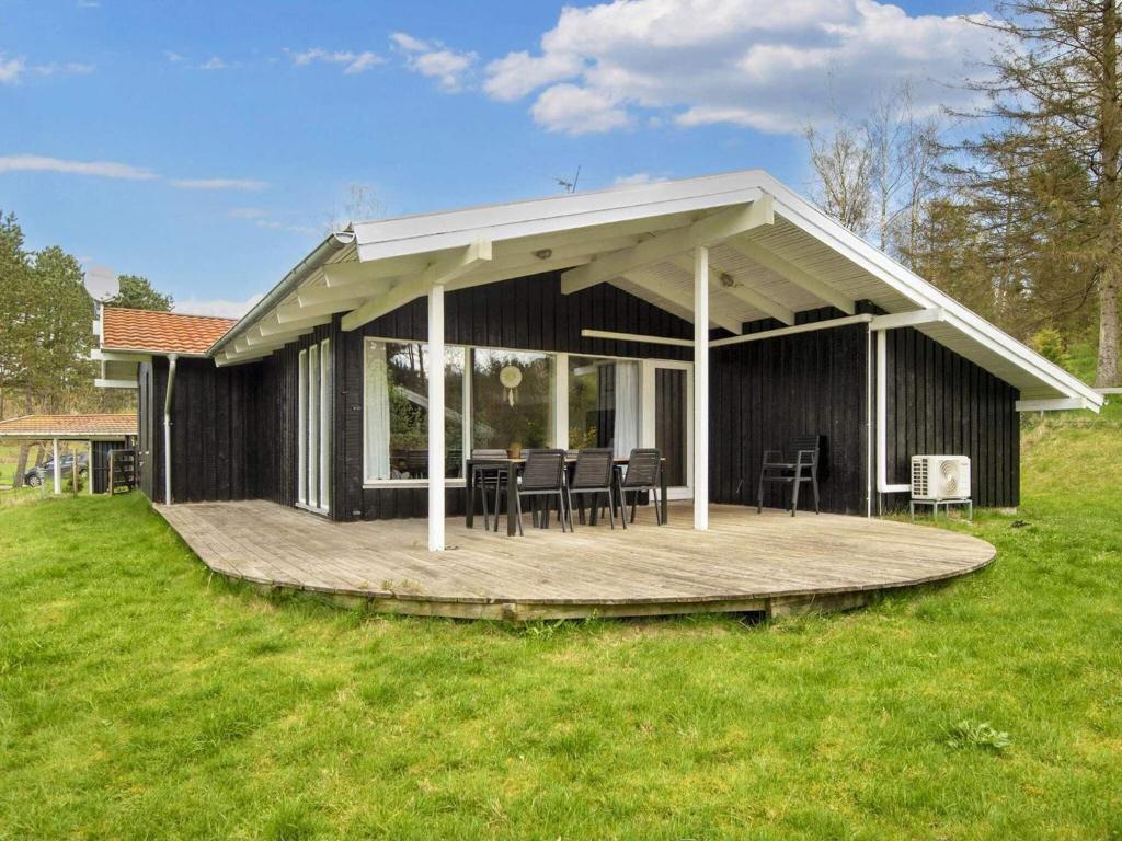 a pavilion with tables and chairs on a wooden deck at 8 person holiday home in Ebeltoft in Ebeltoft