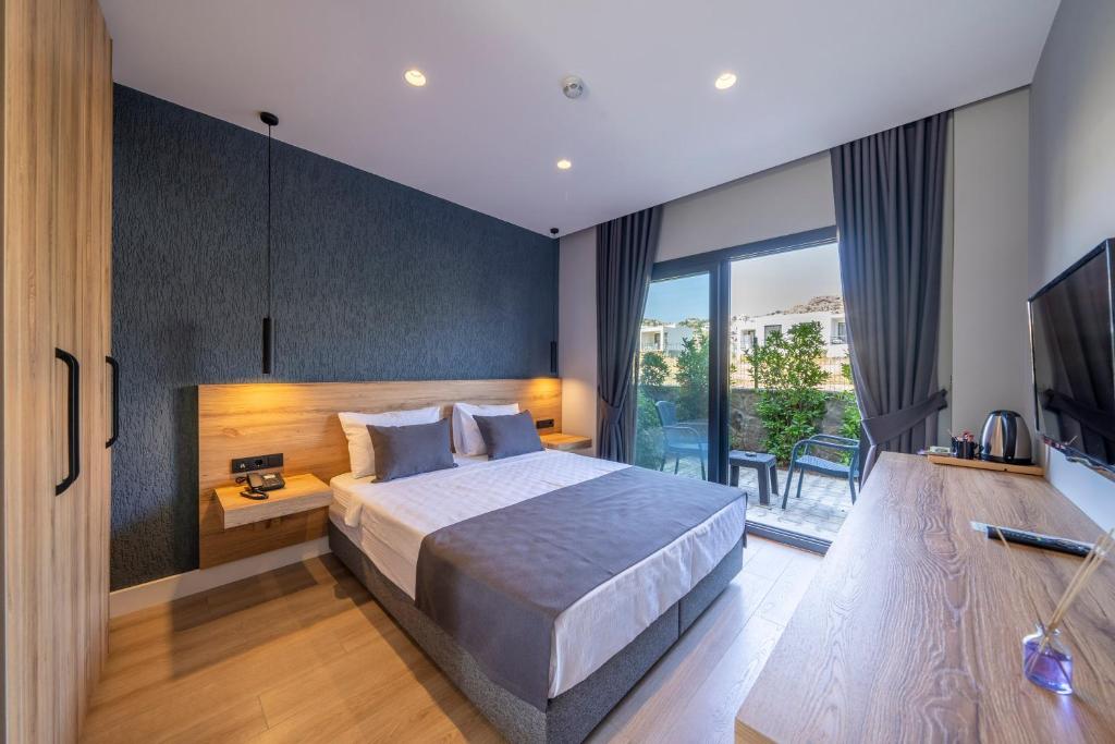 1 dormitorio con 1 cama grande y TV en Gündoğan Suites, en Bodrum City