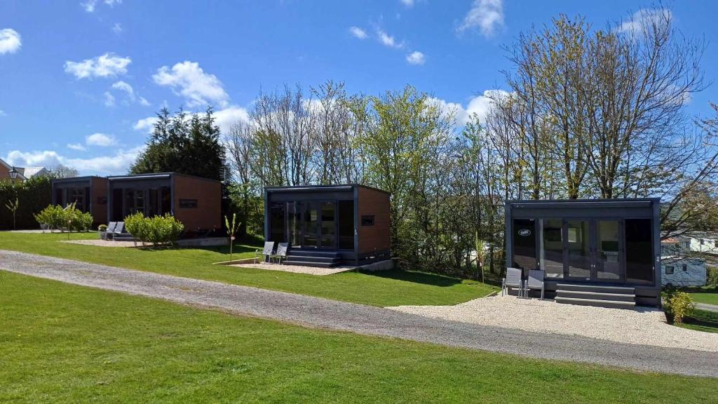 a group of buildings in a park with grass at Luxury Pods at Mornest Caravan Park, Anglesey in Gaerwen