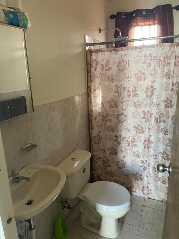 a bathroom with a toilet and a sink and a shower at Casa de Esquina En La Chorrera in La Chorrera