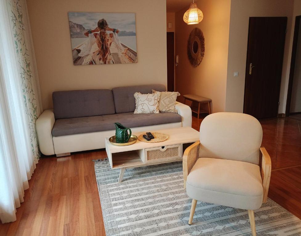 ein Wohnzimmer mit einem Sofa, einem Tisch und einem Stuhl in der Unterkunft Apartament Boho Ustroń in Ustroń