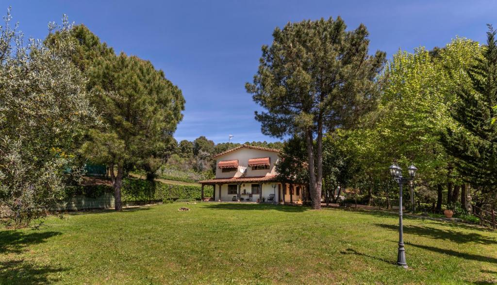 una casa en medio de un patio con árboles en El Bosque de la Herrezuela en Guisando