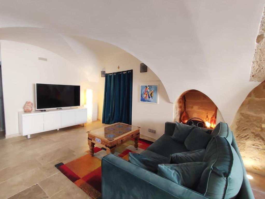 een woonkamer met een bank en een tv bij Grand appartement face au Duché d'Uzès in Uzès