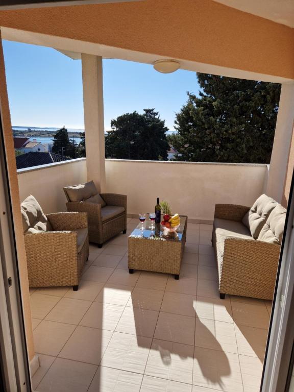patio z kanapami i stołem na balkonie w obiekcie Apartment BOSS w Novalji