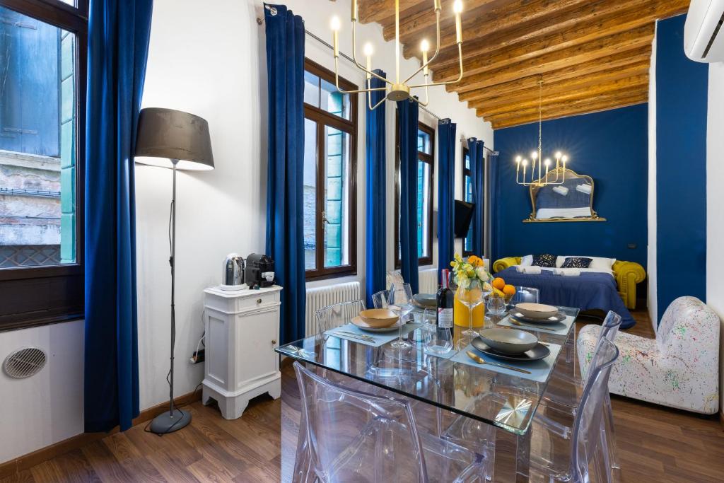 a dining room with blue walls and a room with a bed at [LuxSanstaeFlat] in Venice