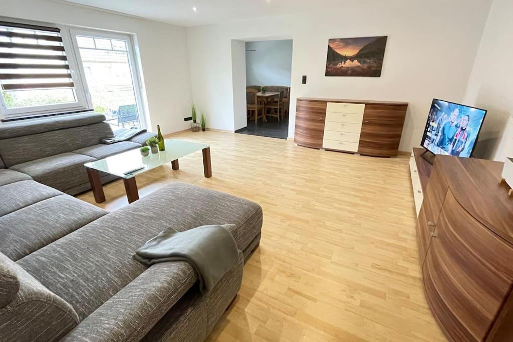 Una sala de estar con un sofá y un televisor de pantalla plana. en Shine Apartment Schwarzenfeld, en Schwarzenfeld