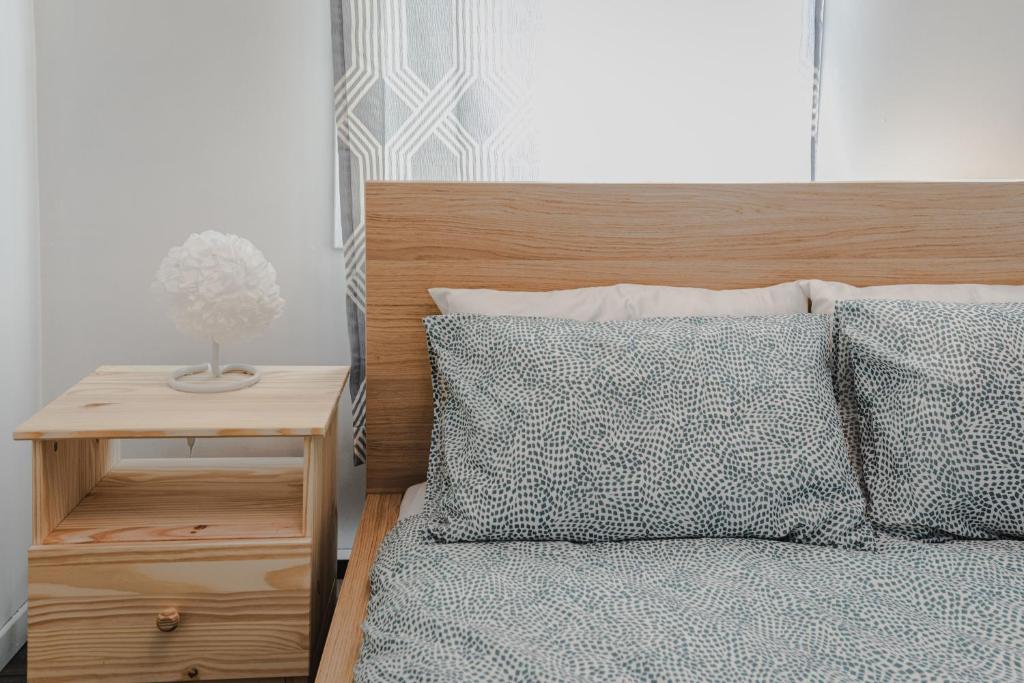 1 dormitorio con 1 cama con 2 almohadas y mesita de noche en Avenir Centre Suite en Moncton