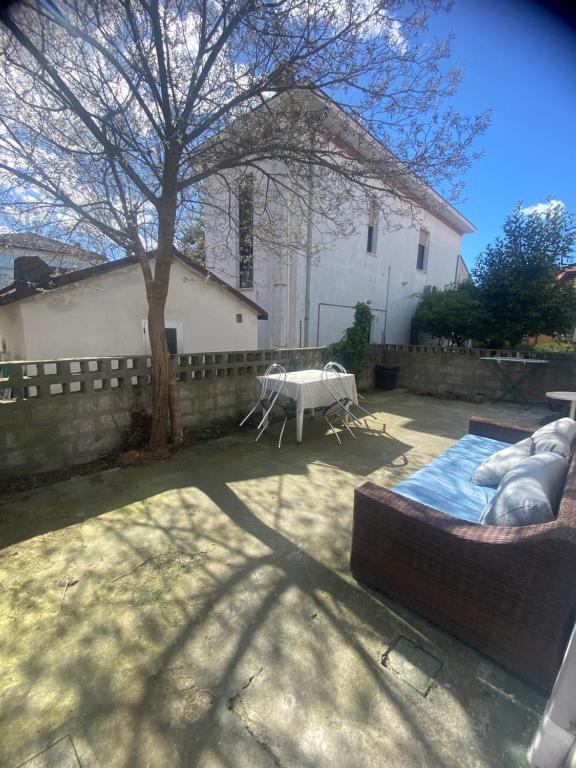 un patio trasero con una mesa y un árbol y un edificio en Casa Elisa 8, en Bellaria-Igea Marina