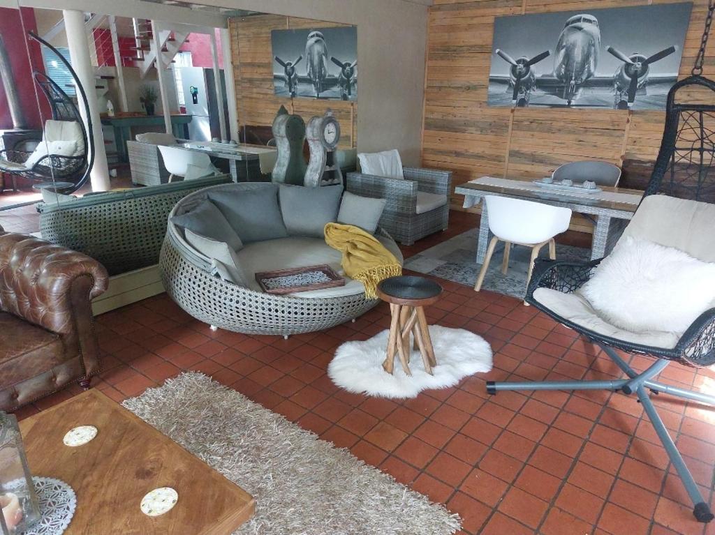 a living room with a couch and chairs at Gallery Guesthouse (La Sky Villa) in Gqeberha