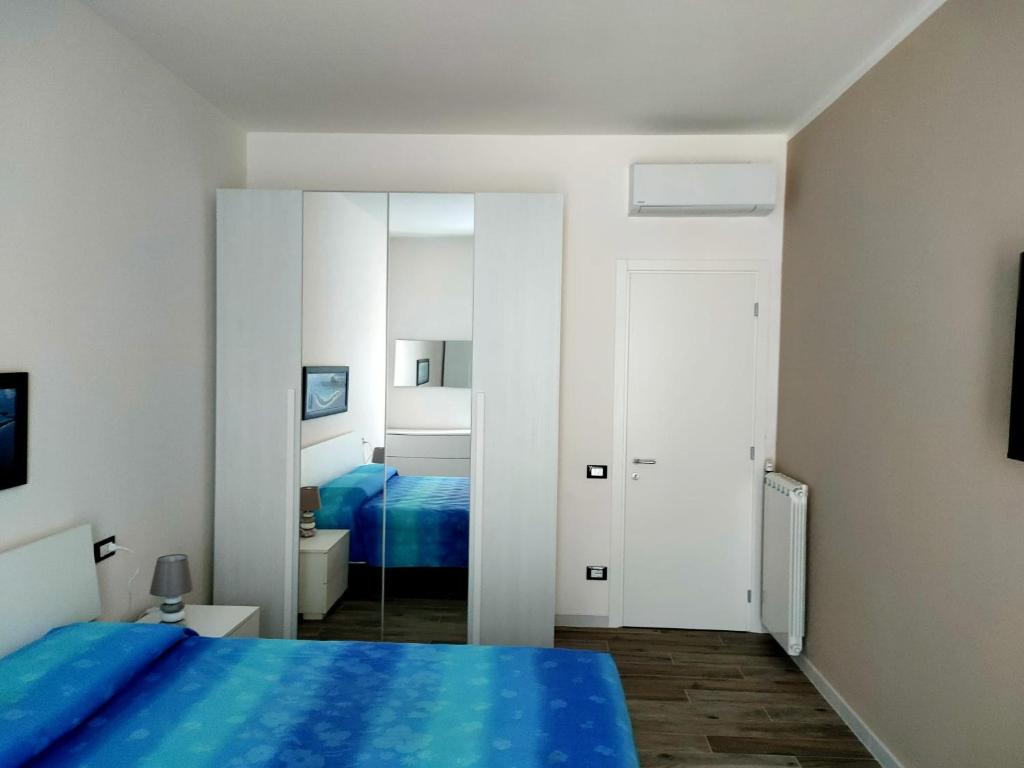 Un dormitorio con una cama azul y un espejo. en Casa di Roby, en Rapallo