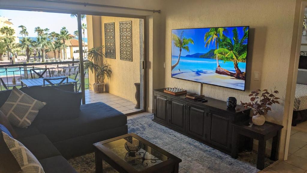 a living room with a couch and a flat screen tv at Princesa de Penasco B208 - Family Beach Getaway in Puerto Peñasco