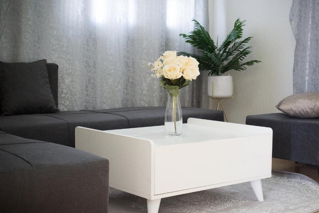 a vase of flowers on a white coffee table in a living room at BEAU SÉJOUR hébergement et spa 
