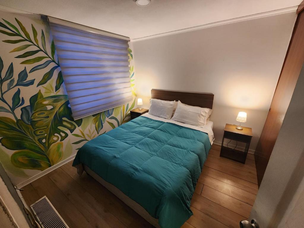 um pequeno quarto com uma cama com um cobertor verde em Maravillosa vista al Volcán em Los Ángeles