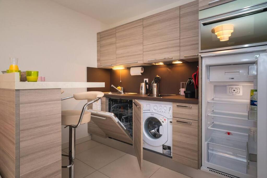a kitchen with a washing machine and a washer at Studio NEUF - PORTES DE MONACO - Confort - Wifi - Clim in Monte Carlo