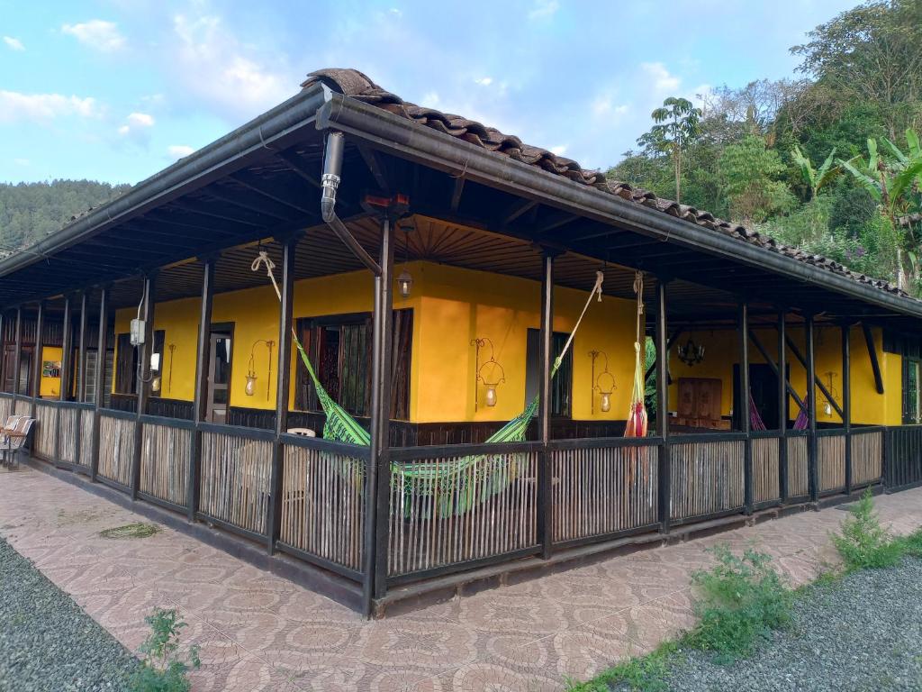 a yellow building with a fence in front of it at Reserva Natural Zarandá in Pereira