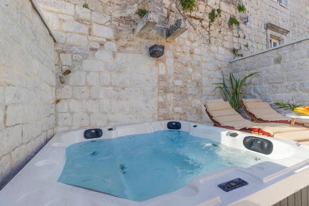 a jacuzzi tub in the corner of a building at House Marijeta and Tonka in Trogir