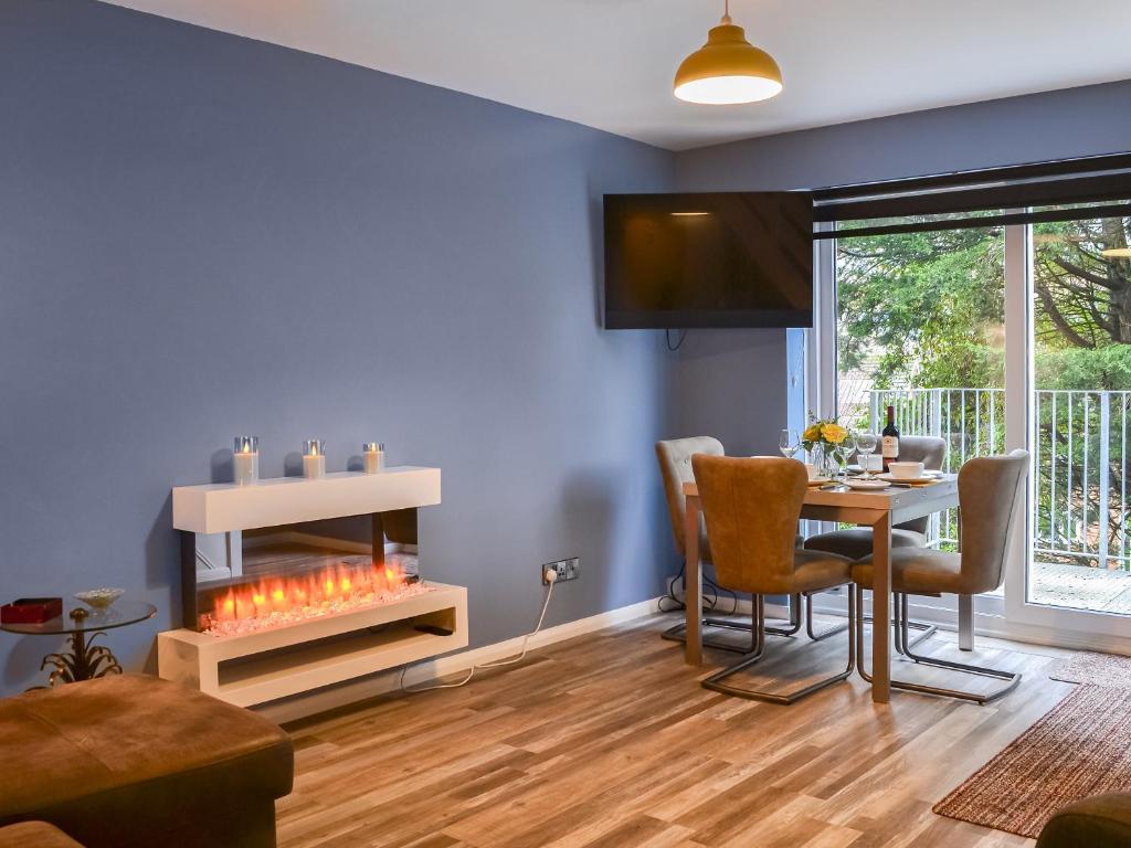 a living room with a table and a fireplace at Daisy By The Sea in Scarborough