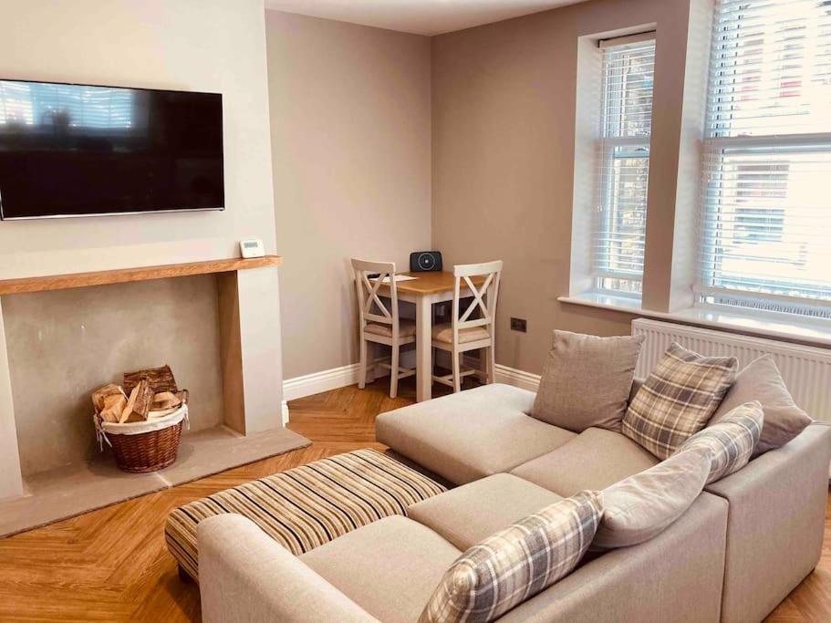 a living room with a couch and a tv at Central Skipton - Devonshire Court Apartment 2 in Skipton