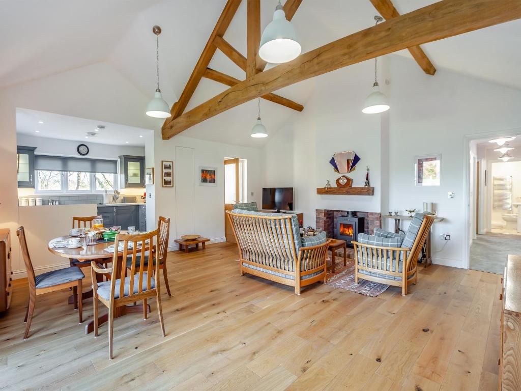 uma sala de estar com mesa e cadeiras em Barn Cottage em Falfield