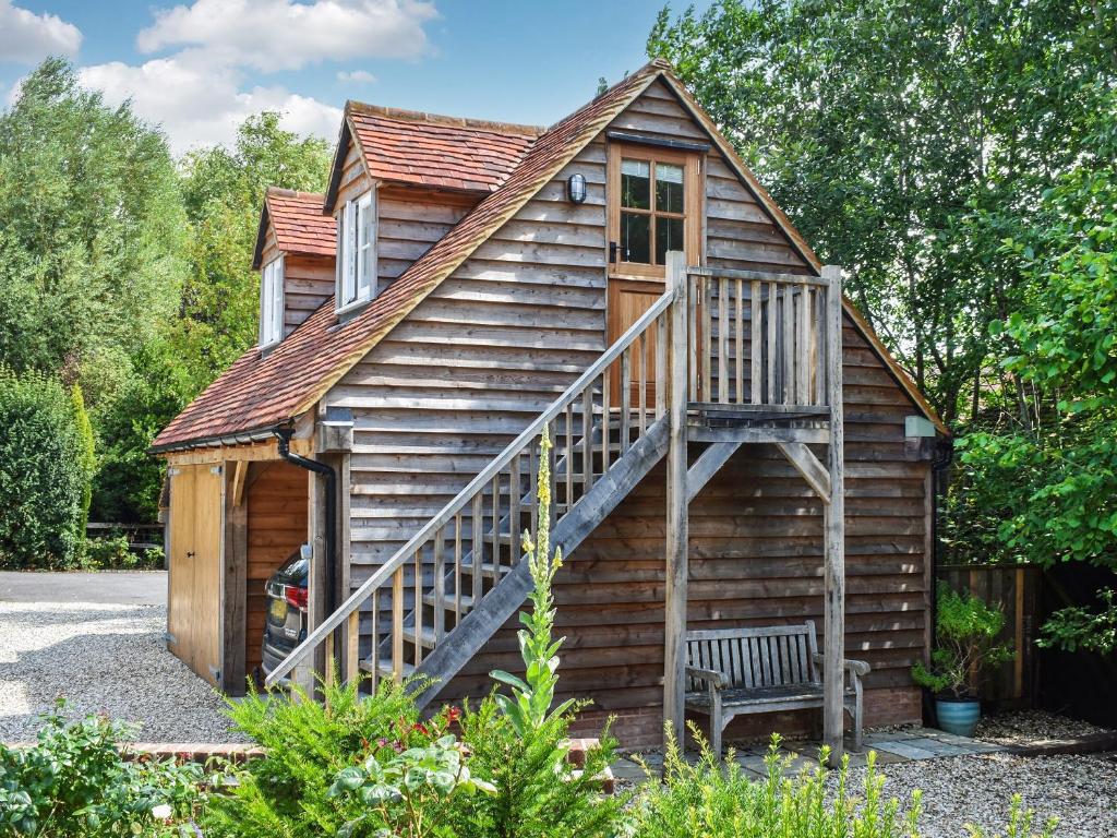a log cabin with a staircase on the side at Hazel Nook in Trotton