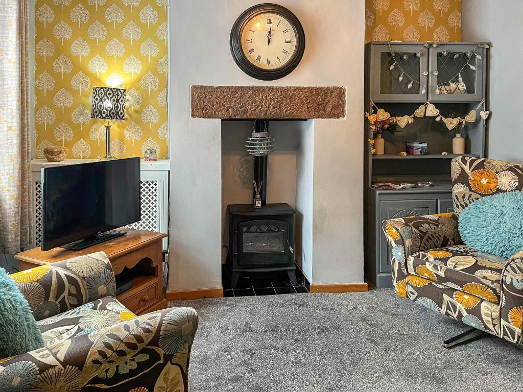 a living room with a tv and a fireplace at Regent House in Leek