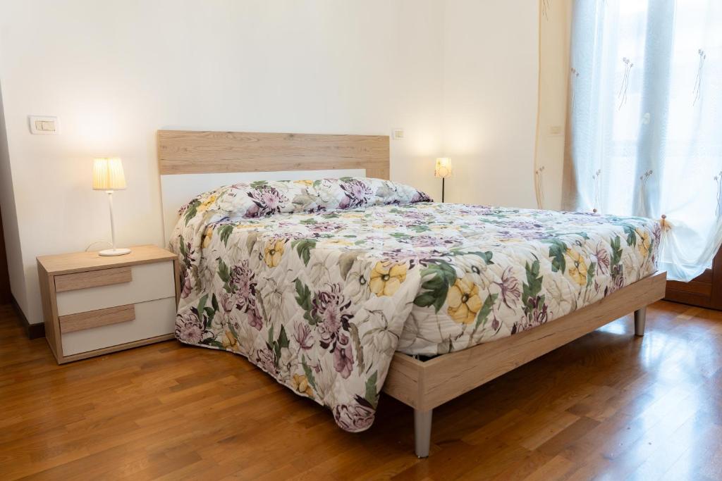 um quarto com uma cama com colcha floral e 2 candeeiros em Marina's Venice garden em San Giacomo