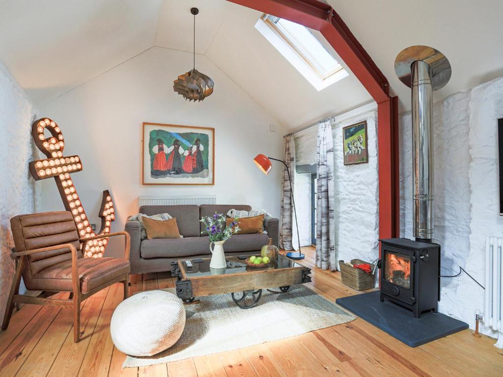 a living room with a couch and a fireplace at The Old Stables in Totnes