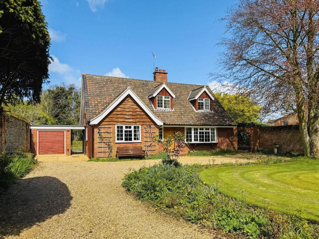 a large brick house with a red garage at Twegan in Trunch