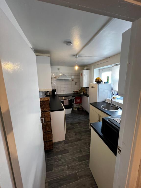 a small kitchen with white cabinets and a sink at Quite apartment in Nottingham