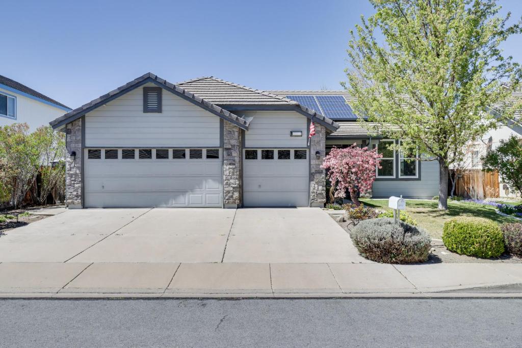 a house with two garage doors on a street at Sparks Home with Fenced Yard 8 Mi to Dtwn Reno! in Sparks