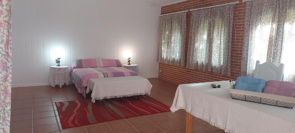 アスケカ・デ・エナレスにあるHABITACION PISCINA Y JARDINのベッドルーム1室(ベッド2台、テーブル2台付)