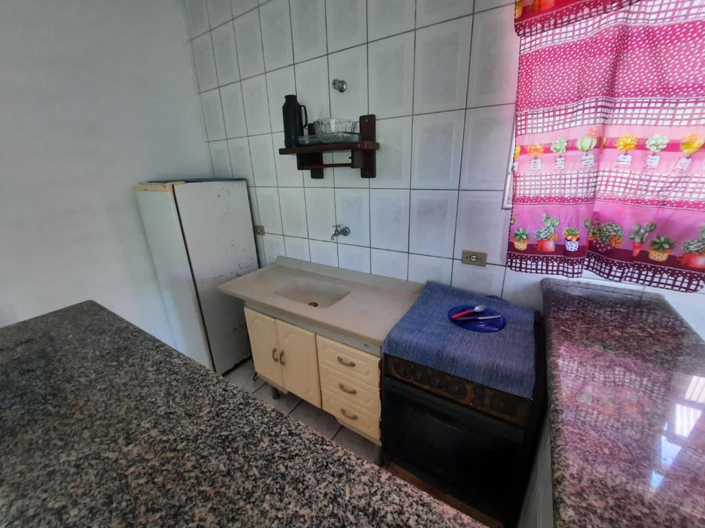 una pequeña cocina con fregadero y nevera. en Flats Divina Ilha, en Ilha Comprida