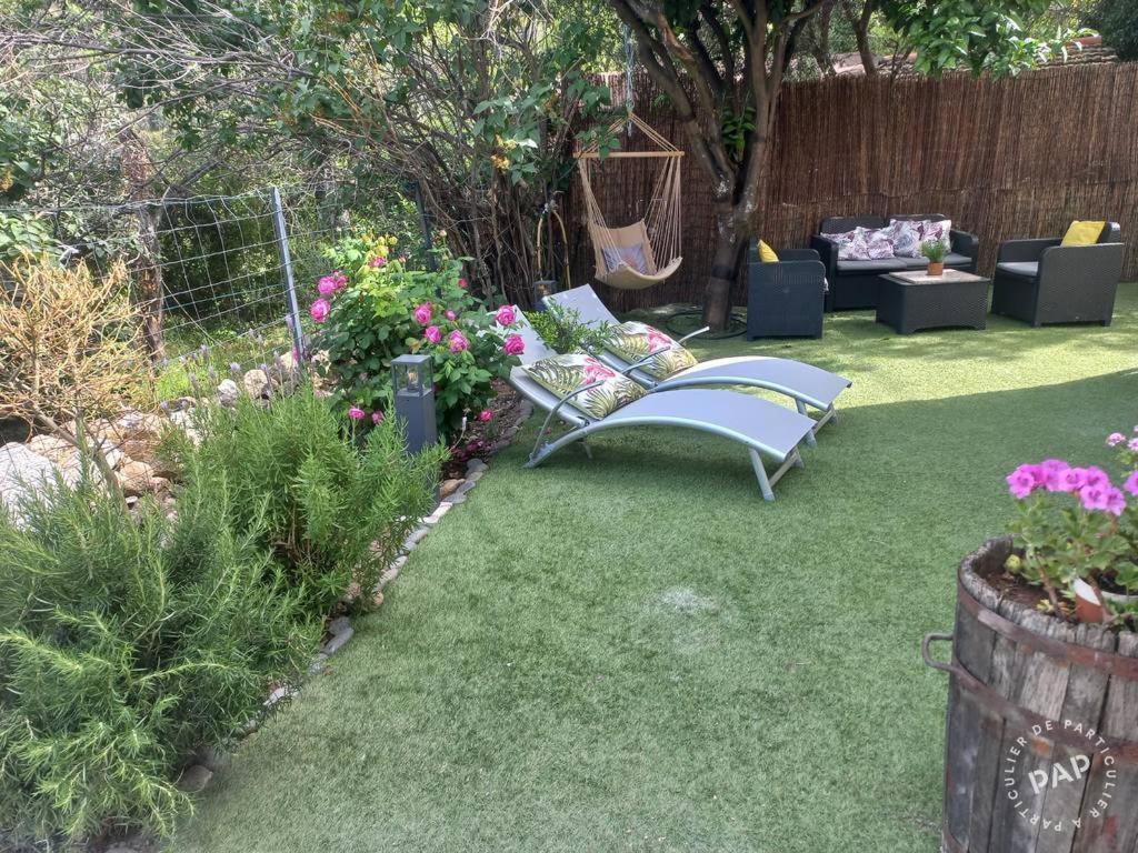 un jardin avec une chaise, un canapé et quelques fleurs dans l'établissement Maison OCCHIATANA, à Occhiatana